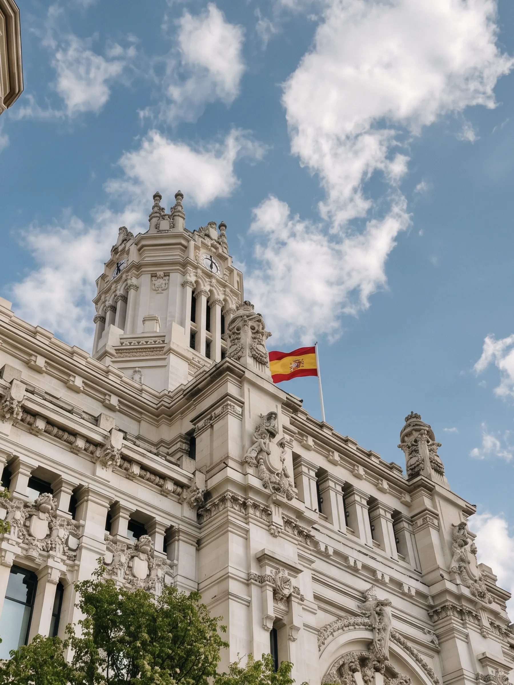 Madrid's Palacio de Cibeles against a bright sky with scattered cloud.