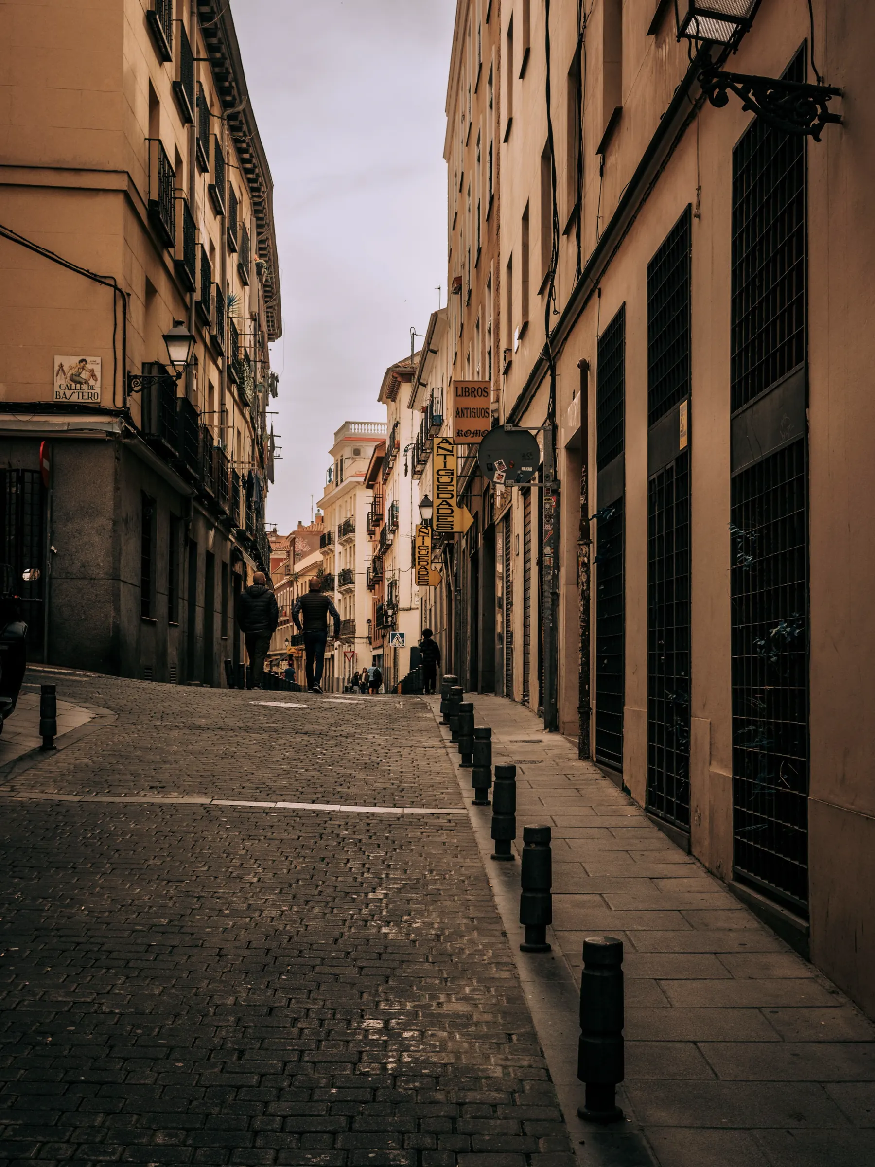 Morning light across a quiet cobbled street in central Madrid.